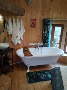 ein Badezimmer mit einer großen Badewanne und einem Waschbecken in der Unterkunft La Tour de Ver Gite atypique Possibilité table d'hôtes sur réservation in Ver