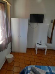 um quarto com um armário branco com uma televisão em Bed and fly Aeroporto Catania reception h24 em Catânia