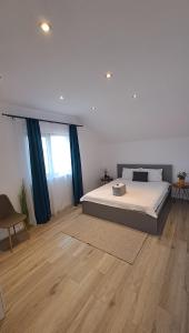 Homestay near motorway في Giarmata: غرفة نوم بسرير كبير وارضية خشبية