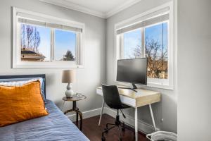 a bedroom with a bed and a desk with a computer at Executive 2bed 3bath Townhome, James Bay/Dallas Rd. 2 Parking Spots, Hot Tub! in Victoria