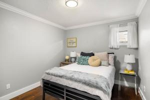 Un dormitorio con una cama con almohadas. en Executive 2bed 3bath Townhome, James Bay/Dallas Rd. 2 Parking Spots, Hot Tub! en Victoria