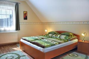 a bedroom with a bed with green pillows and a window at Napsugár Vendégház in Tihany +12 photos