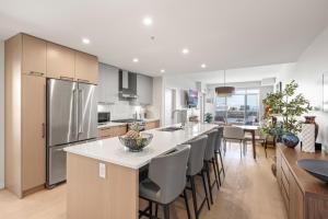 a kitchen with a large island with a counter top at Modern 1000sqft+ Condo in Sidney, Ocean Views, Parking. Walk to Shops, Restaurants! in Sidney