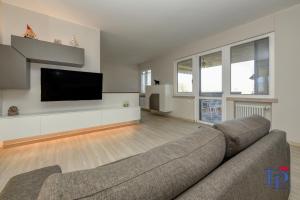 ein Wohnzimmer mit einem Sofa und einem Flachbild-TV in der Unterkunft Desenzanoloft H2o in Desenzano del Garda