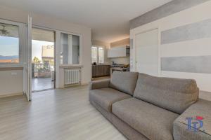ein Wohnzimmer mit einem Sofa und einer Küche in der Unterkunft Desenzanoloft H2o in Desenzano del Garda