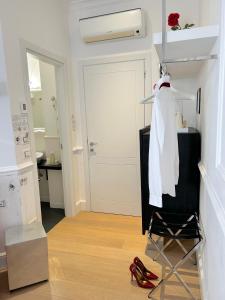 a bathroom with a white robe on a rack and red shoes at Guicciardini 24 in Florence