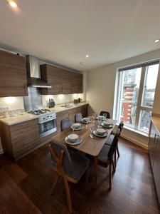 een keuken met een tafel met stoelen en een eetkamer bij Deluxe 3 bed spacious & central next to station in Londen