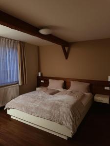 a bedroom with a large bed and a window at Gasthaus Lindenhof in Much
