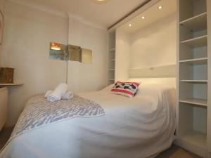 1 dormitorio con 1 cama blanca grande con estanterías en Mooringside, en Truro