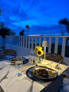 a table with a plate of food and a sunflower on it at Atlantica Eleon Grand Resort in Tragaki