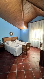 1 Schlafzimmer mit 2 Betten und Holzdecke in der Unterkunft Casa Rural Piedras de Benquerencia in Benquerencia