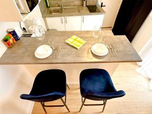 a kitchen with a table with two chairs and a sink at La vacancière - 308 in Rouen