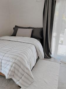 a bed with a white comforter in a bedroom at Playa Ziba in Ciudad del Carmen
