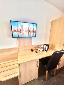 a room with a desk with a tv on the wall at Hotel Karlin in Prague