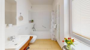 a bathroom with a sink and a toilet and a tub at Südkap H-02 in Pelzerhaken +35 photos