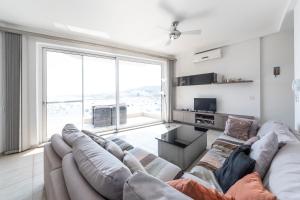 a living room with a couch and a large window at Sea View 2 Bedroom Apartment in St. Paul's Bay