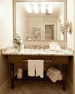 a bathroom with a sink, mirror, and towel rack at Hotel Provincial in New Orleans