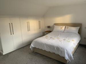 a bedroom with a white bed and white cabinets at 1 bedroom self contained separate Annexe in Exeter in Ide