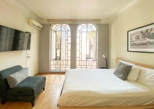 um quarto com uma cama grande e uma cadeira em Casa Condesa Amatlan 84 em Cidade do México