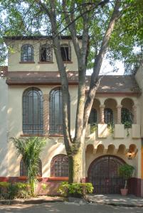 uma casa com uma árvore em frente em Casa Condesa Amatlan 84 em Cidade do México