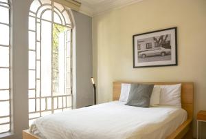1 dormitorio con cama y ventana grande en Casa Condesa Amatlan 84, en Ciudad de México