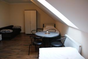 a room with a table and chairs and a bed at Zacisze Mazury in Kętrzyn