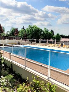una gran piscina con sillas en la parte superior de un edificio en Villa de 3 chambres avec piscine partagee sauna et jardin clos a Ecuras, en Écuras