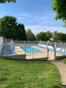 una gran piscina con sillas azules en un patio en Villa de 3 chambres avec piscine partagee sauna et jardin clos a Ecuras, en Écuras
