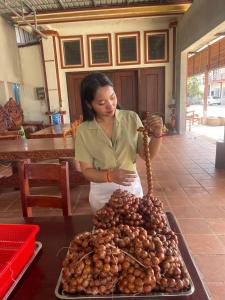 a woman standing in front of a pile of food at Samnang Leap guesthouse in Senmonorom