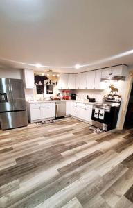 una cucina con armadietti bianchi e pavimenti in legno di Direct trail access/central location/Ample parking a Colebrook