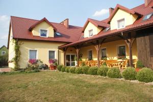 a large yellow house with a red roof at Zacisze Mazury in Kętrzyn