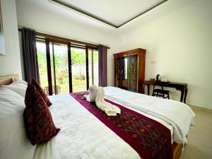 um quarto com uma cama com duas toalhas em Asri Dana Guest House em Ubud