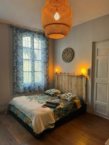 1 dormitorio con 1 cama y reloj en la pared en Arles Centre historique Studio climatisé 1 à 2 personnes, en Arles