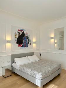 a white bedroom with a bed and a mirror at Guicciardini 24 in Florence