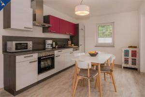 eine Küche mit einem Tisch, Stühlen und einer Mikrowelle in der Unterkunft Villa Doris Whg 1 Merilyn in Heringsdorf