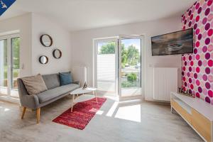 ein Wohnzimmer mit einem Sofa und einem TV in der Unterkunft Villa Doris Whg 3 Flora in Heringsdorf