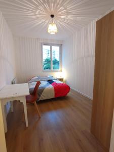 a bedroom with a bed and a desk and a window at Appartement lumineux et spacieux 70m2 proche de tout - 3 chambres in Nantes