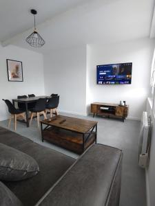 a living room with a couch and a table and a tv at Appartement lumineux et spacieux 70m2 proche de tout - 3 chambres in Nantes