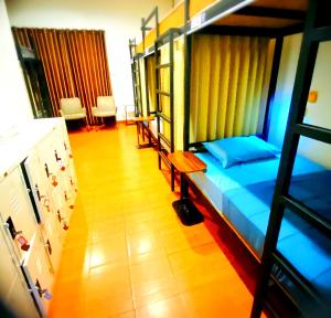 ein Schlafzimmer mit einem Etagenbett mit blauer Bettwäsche und Holzboden in der Unterkunft Three Hostel at Night Market Pakchong in Ban Sao Thong
