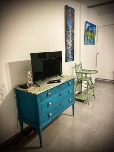 une commode bleue avec une télévision en haut dans l'établissement La galerie du peintre, à Saint-Laurent-de-la-Salanque
