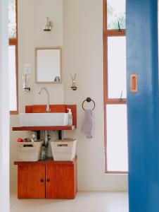 łazienka z umywalką i 2 oknami w obiekcie Las Terrazas de Barili w mieście Barili