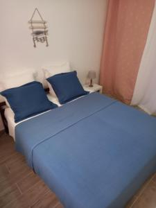 a blue bed with two pillows on top of it at Saint Laurent de la Salanque Charmant T2 classé 3 étoiles in Saint-Laurent-de-la-Salanque