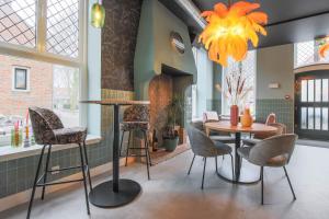 a dining room with a table and chairs and a chandelier at Hotel Zoet & Slaap in Biggekerke