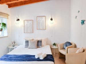 - une chambre avec un lit et une chaise dans l'établissement Minha Casa Sua Casa - Centro Ferragudo, AC, WiFi, à Ferragudo