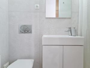 La salle de bains blanche est pourvue d'un lavabo et de toilettes. dans l'établissement Minha Casa Sua Casa - Centro Ferragudo, AC, WiFi, à Ferragudo
