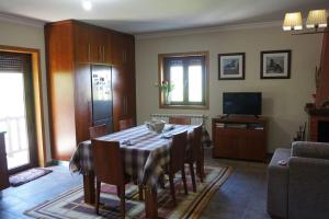 a living room with a table and chairs and a television at Casa Golden in Bragança