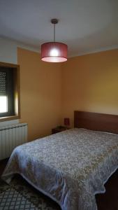 ein Schlafzimmer mit einem Bett und einem rosa Licht in der Unterkunft Casa Golden in Bragança