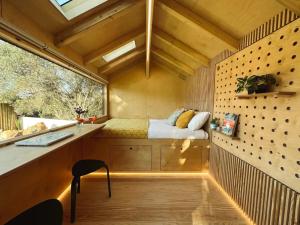 Habitación pequeña con cama y ventana en Tiny Whale Lodge, a unique space for groups, en Bensafrim
