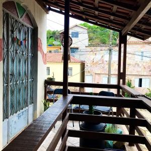 a balcony with a table and chairs and a window at Hospedaria Dos Astros in São Thomé das Letras
