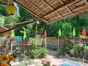 a garden with a wooden fence and colorful umbrellas at YOUMEBED MOTOR INN at Kambal Kubo Resthouse in Antipolo